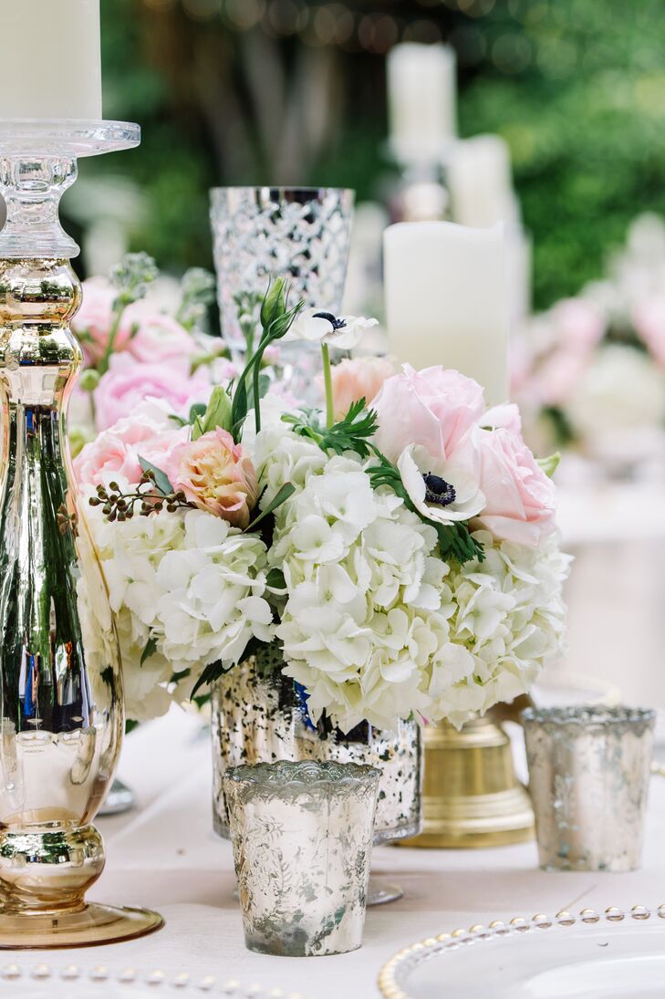 Tall candleholders were paired with short mercury glass vases filled with white hydrangea, white anemones and pink peonies.