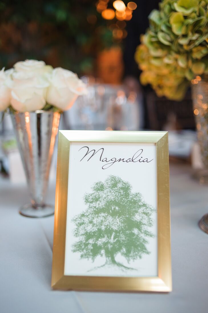 Tree-themed table numbers were framed in gold.