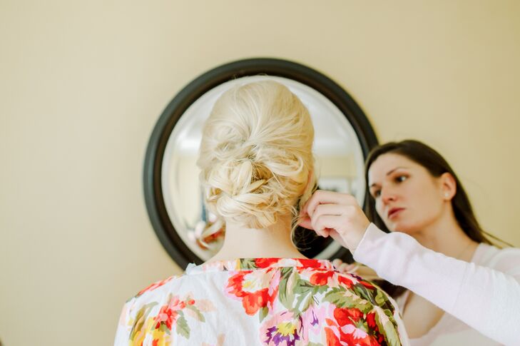 Behind the Veil styled Corinne's hair into a messy bun updo, parted to the side. This style pulled back her hair, which allowed her beautiful stud earrings to sparkle and shine.