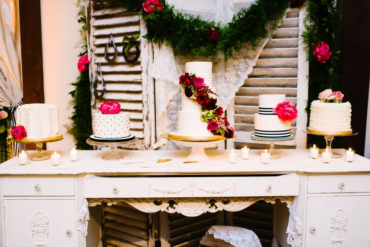 Paige and Matt had five wedding cakes! They supplemented their main three-tier cake with four single or double-tier confections, which each continued the theme of black-and-white stripes or textured whites to match their linens. Bright pink peonies or garden roses added color to each cake. A shabby-chic table with a backdrop of vintage windowpanes completed the dessert display.