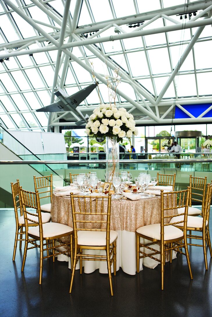 Gold-sequined linens were topped with tall glass vases filled with lush white roses.