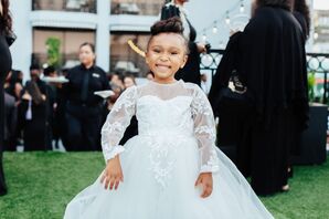 Sweet Flower Girl With an Updo and a White Ballgown