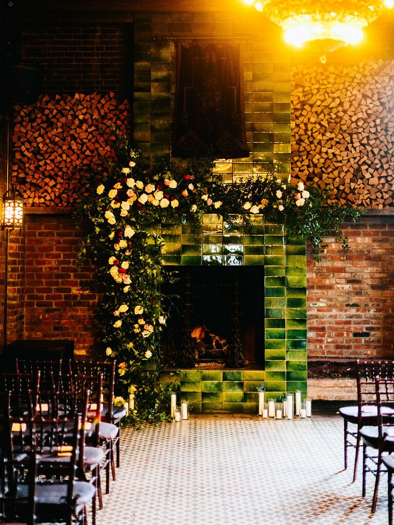 vintage green tiled wedding fireplace decorated with fresh flower arch on one side