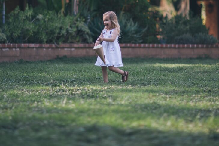The couple's flower girl wore an embroidered white dress and carried a cone of ivory hydrangea petals.