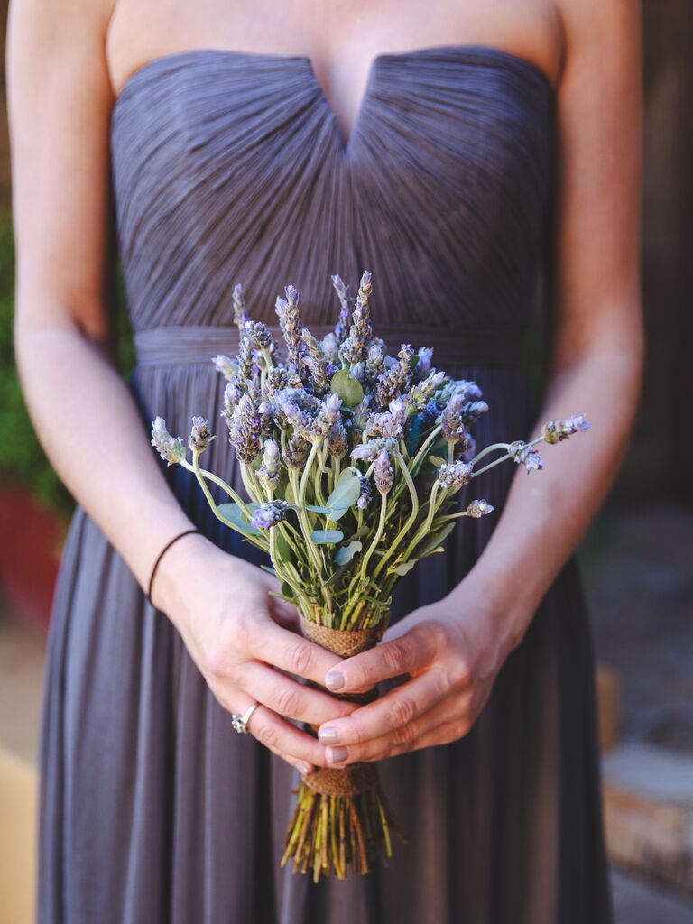 A bridesmaid holds a lavender bouquet.