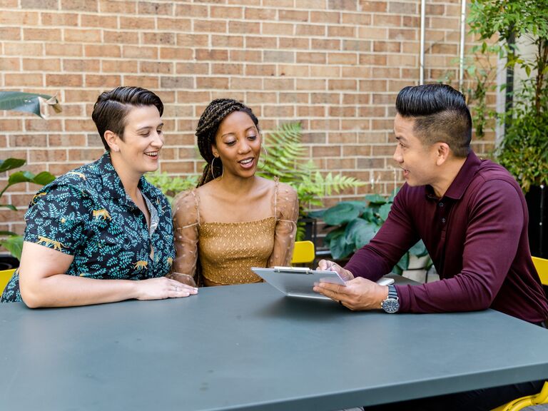 A couple go over logistics with their wedding planner before the big day.