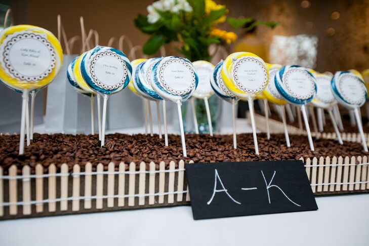 As escort cards, Dawn and Chad labeled blue and yellow lollipops with their guests' names and table numbers. These lollipops were arranged to look like flowers in a garden.