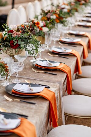 Place Settings With Black Plates and Orange Napkins