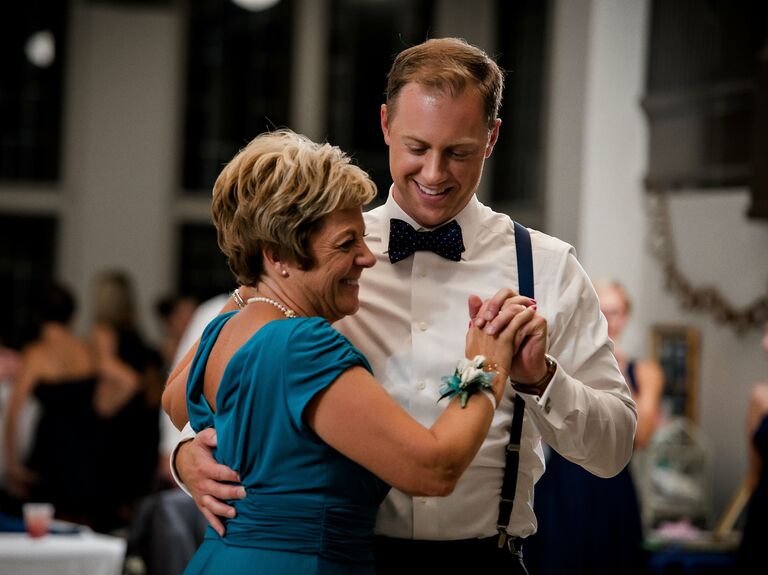 Groom and his mother dancing together for their parent dance. 