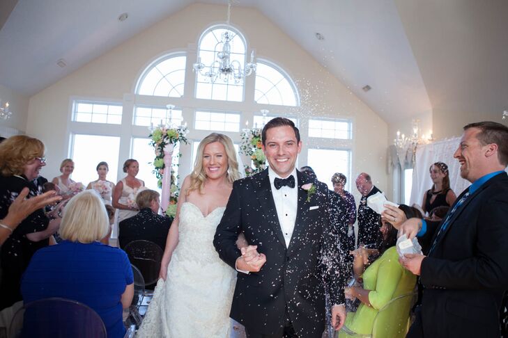 Brian wore a custom-made Brooks Brothers tuxedo for the formal seaside affair in Corolla, North Carolina. The groomsmen echoed his look with JoS. A Bank attire. The men added a little romance to their look with pink rose boutonnieres that went beautifully with the blush and peach bouquets.