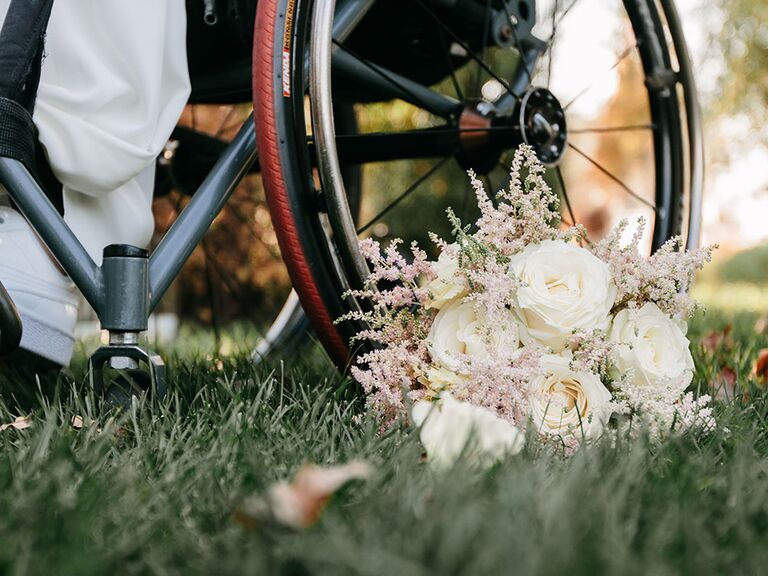 white rose wedding bouquet on grass beside wheelchair