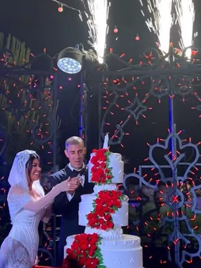 Kourtney Kardashian and Travis Barker cutting their wedding cake